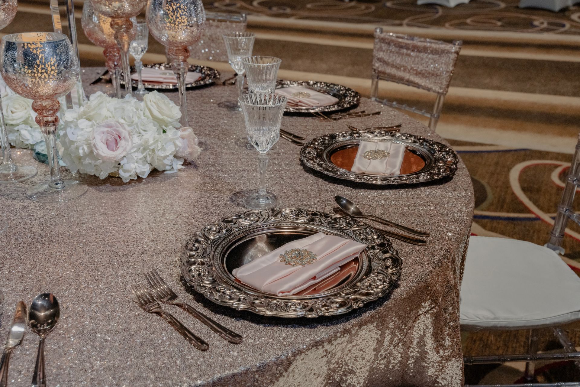 A table set for a wedding reception with plates , utensils , and candles.