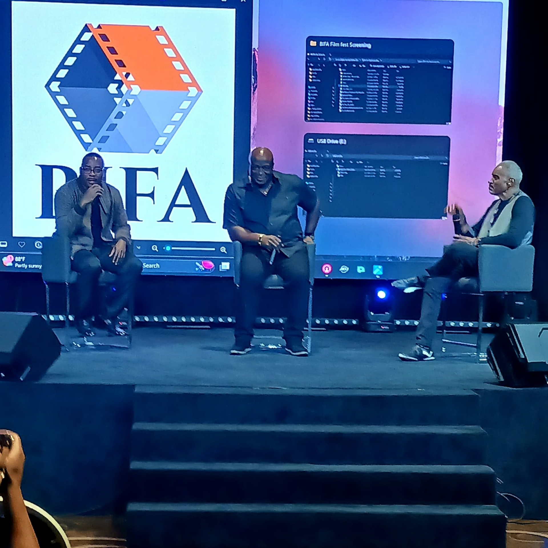 Three men sit on a stage in front of a pfa logo