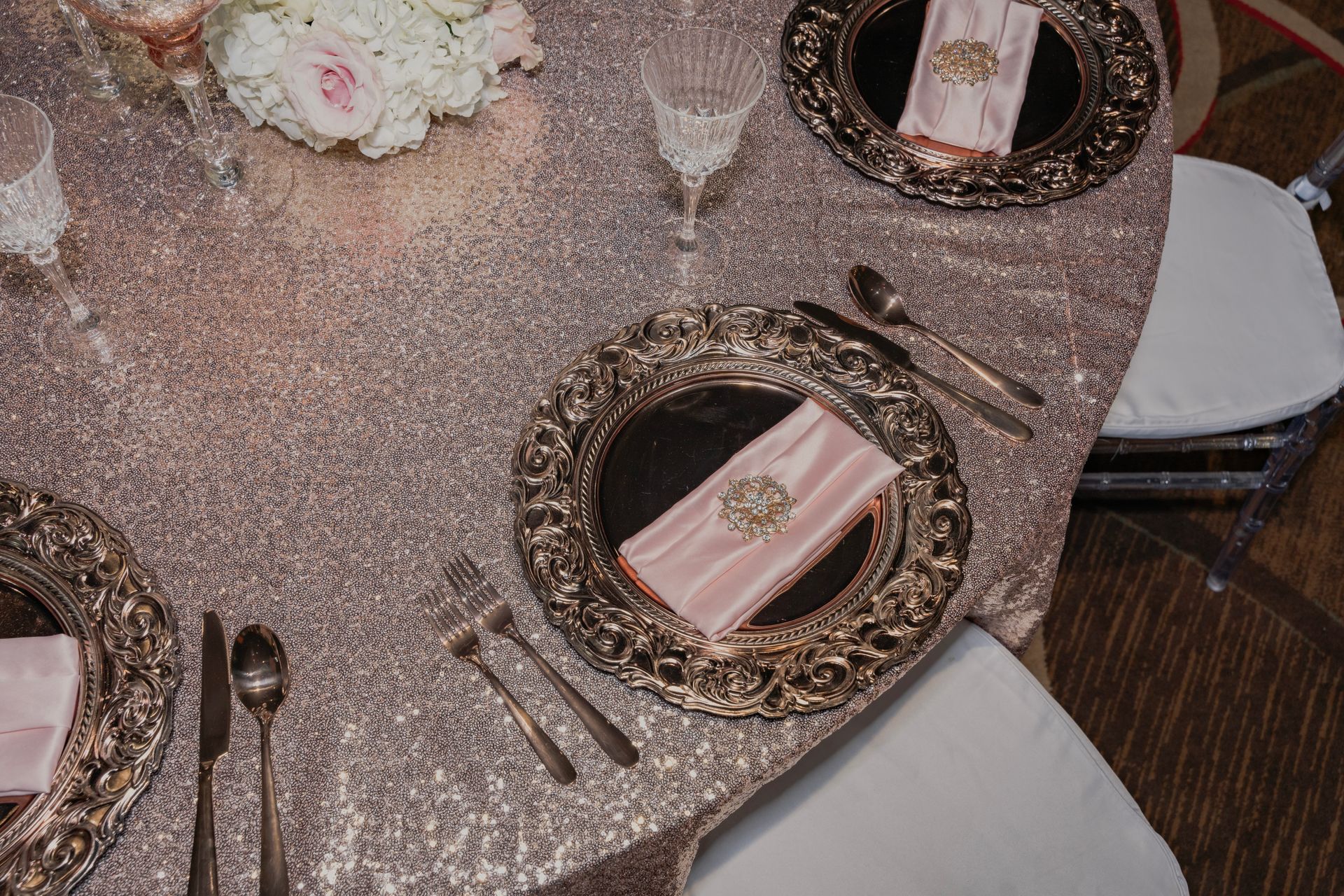 A table with plates , silverware , and a vase of flowers on it.