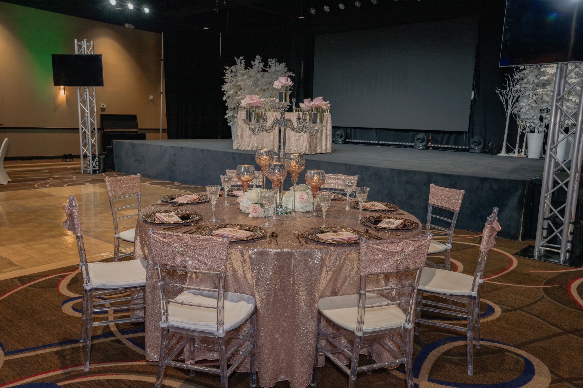 A table and chairs are set up for a wedding reception in a large room.