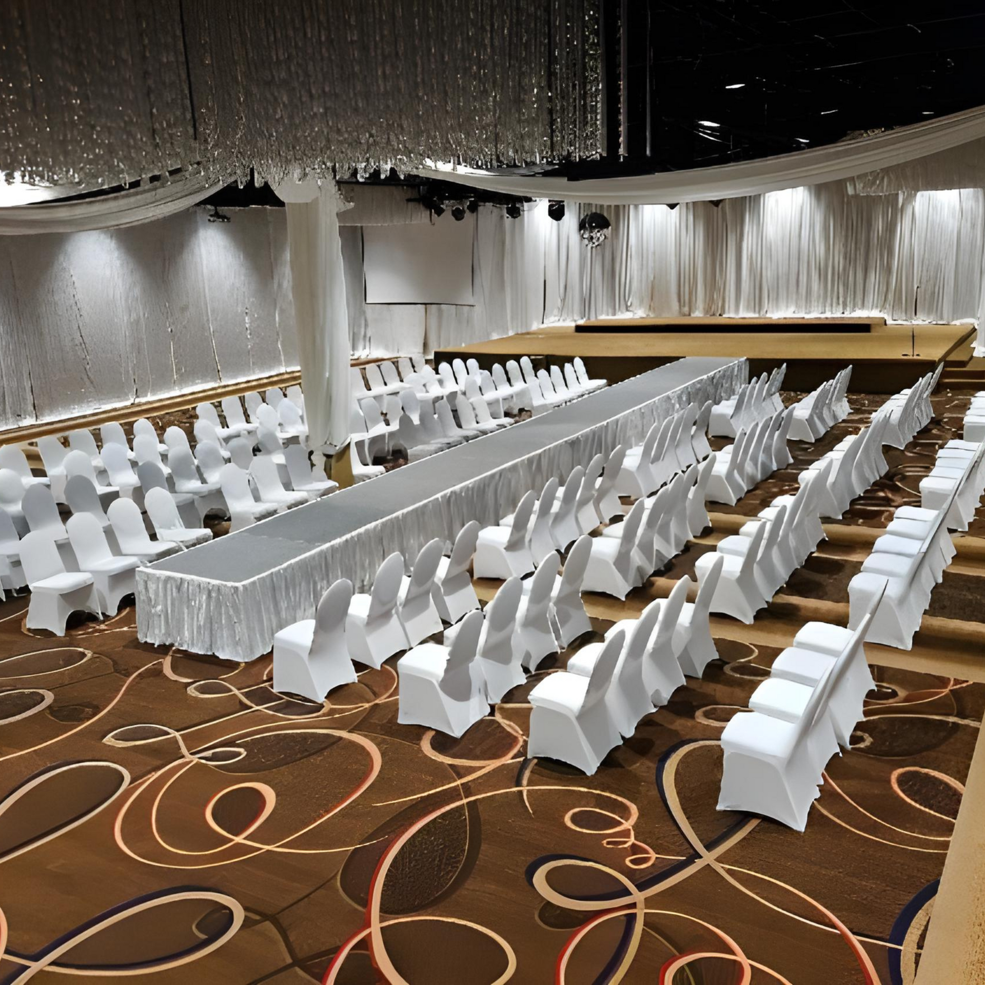 A large room with rows of chairs and a long table