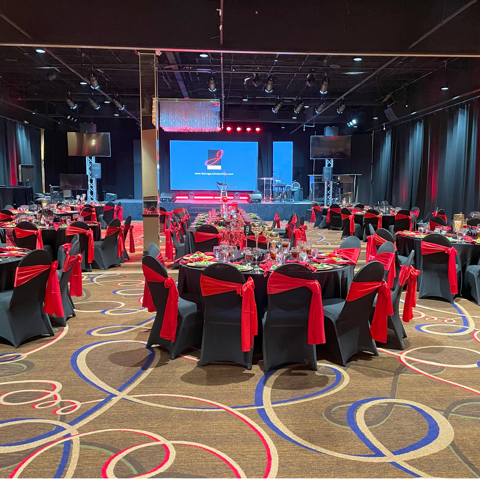 A large room with tables and chairs set up for a party