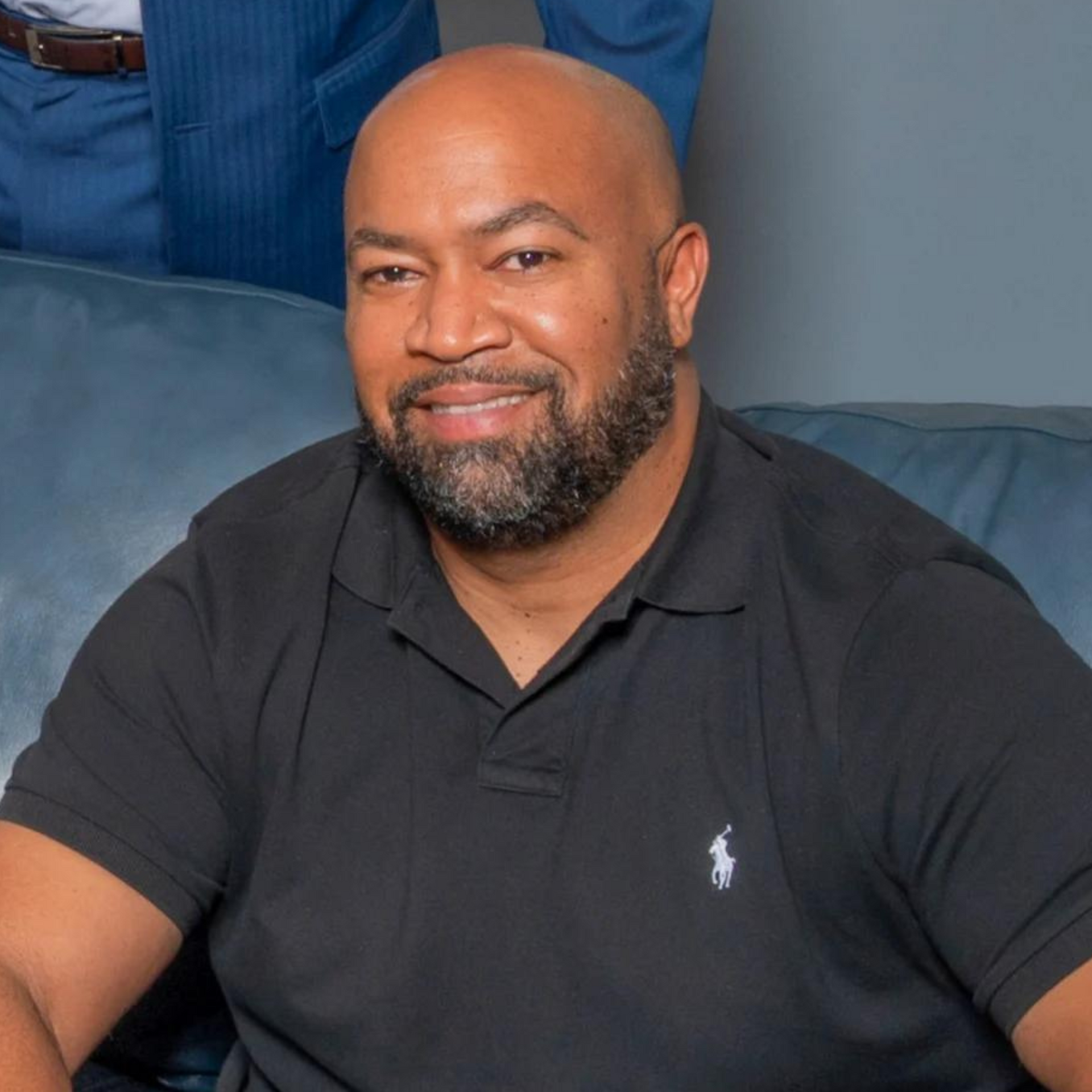 Ben Williams wearing a black polo shirt smiling for the camera