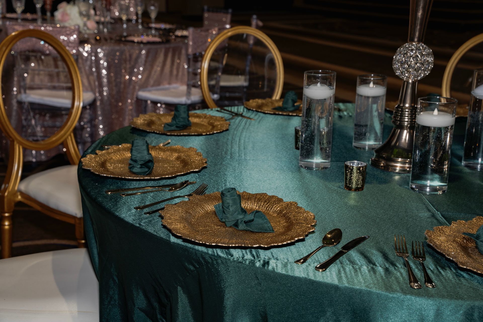 A table with plates , silverware , and candles on it.