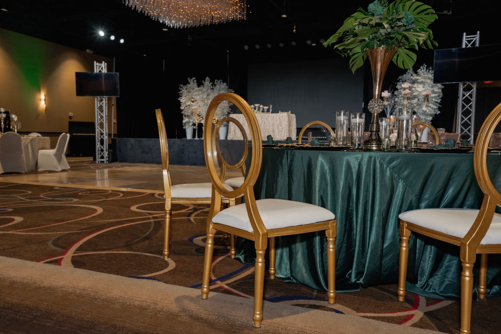 A row of chairs are sitting in front of a table with a green table cloth.