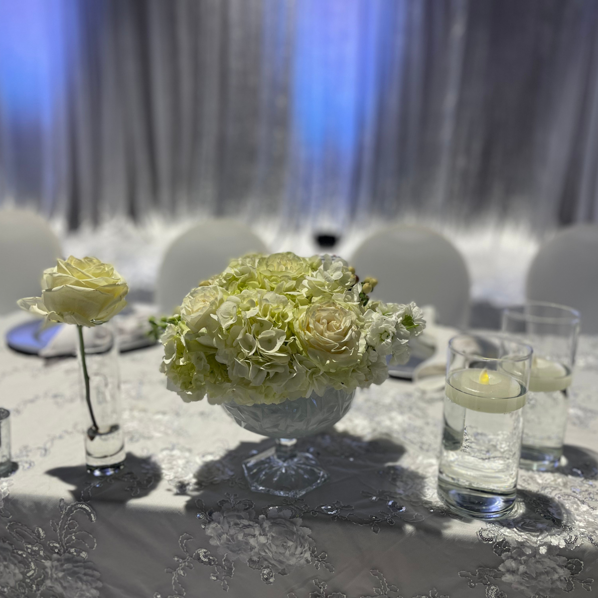 A vase filled with white flowers is sitting on a table.