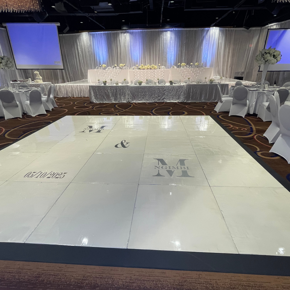 There is a large white dance floor in the middle of the room.
