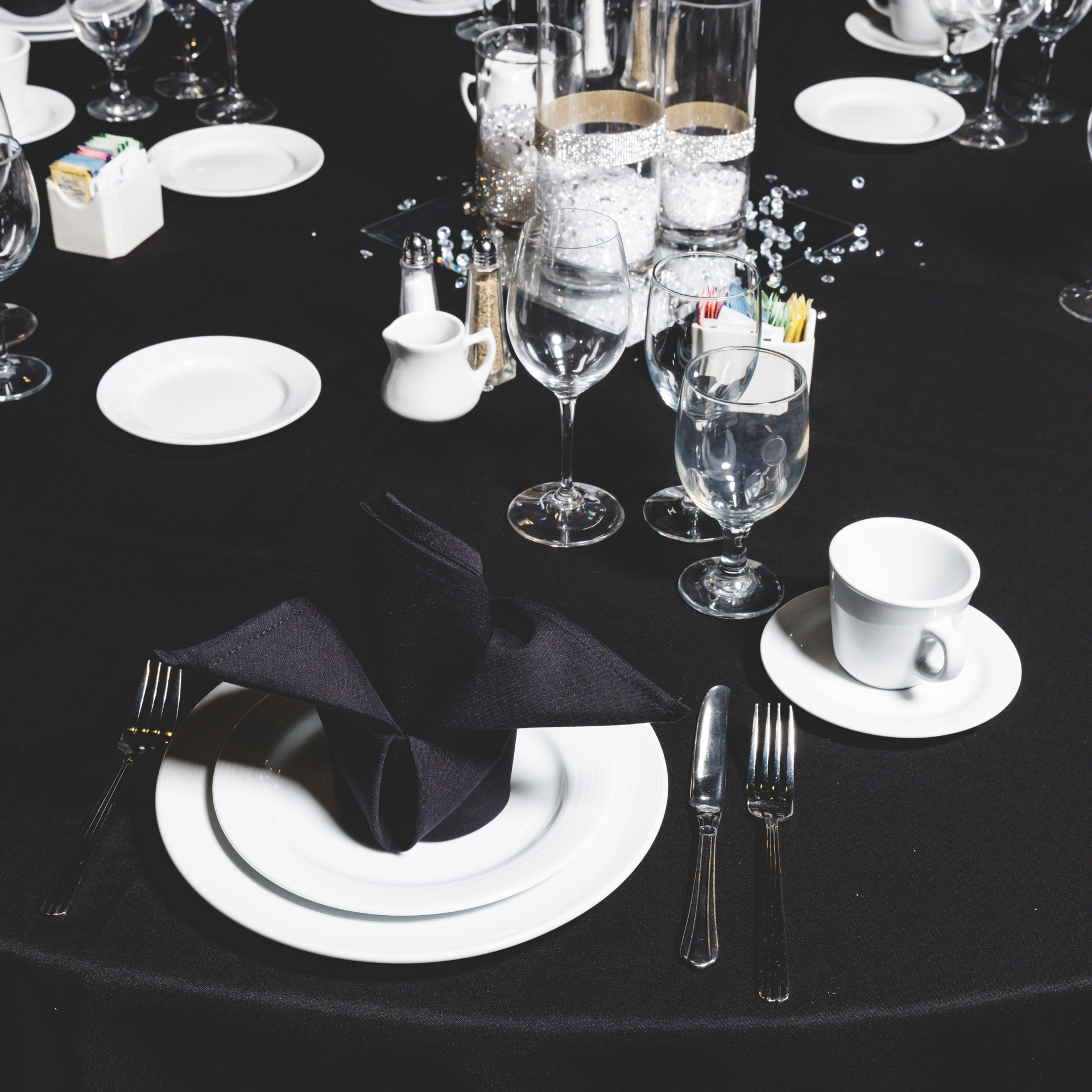 A table with plates glasses and a napkin on it