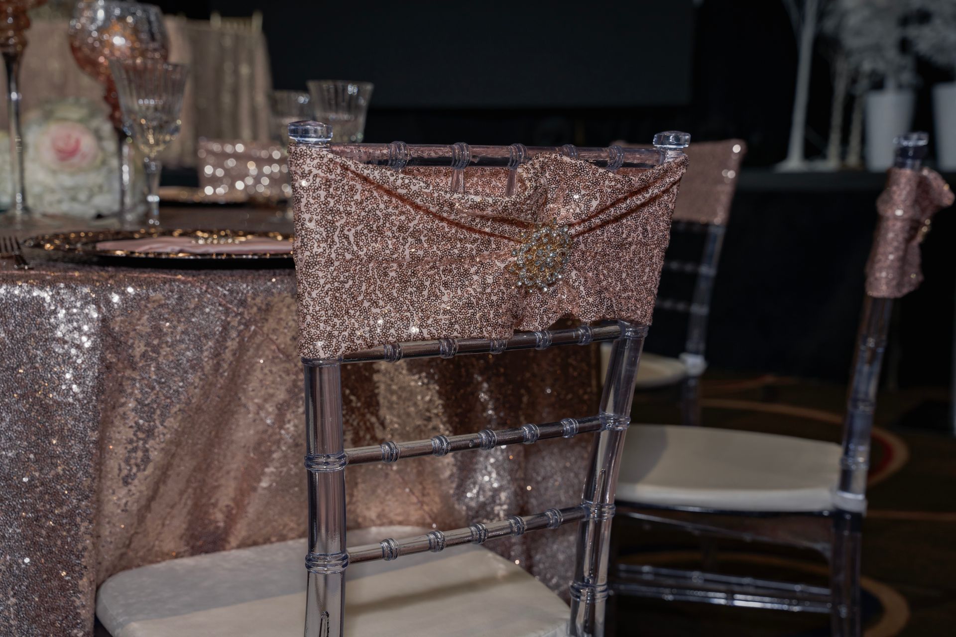 A chair with a bow on the back is sitting in front of a table.