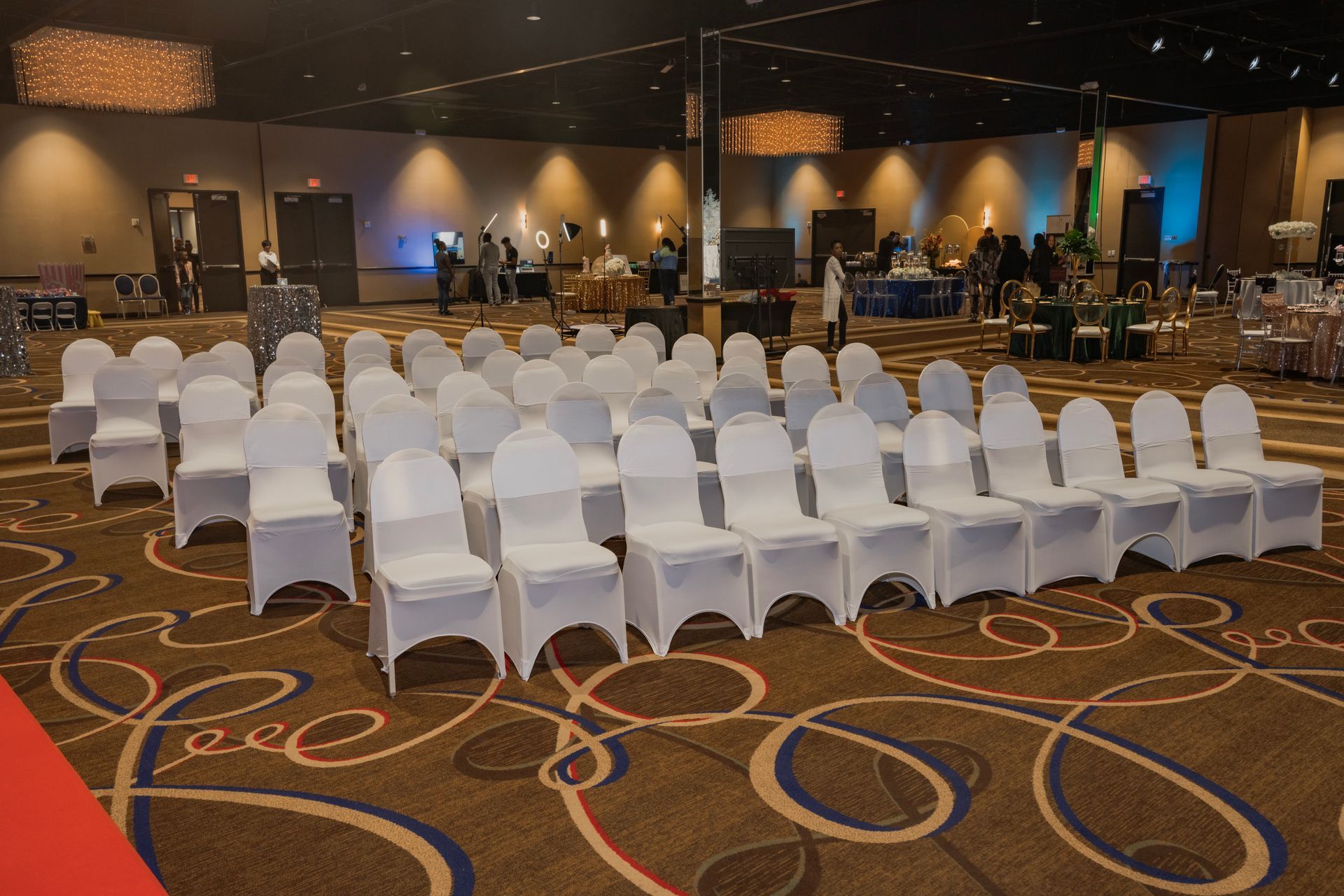 Rows of white chairs are lined up in a large room.