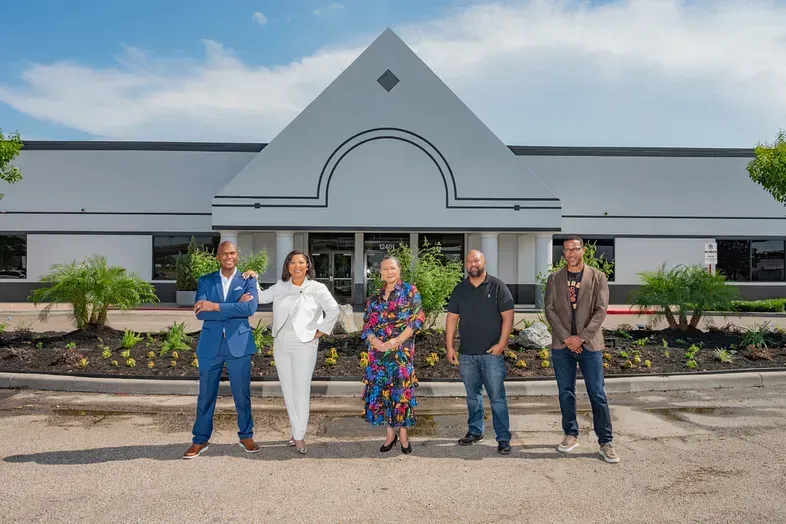 The Founding members are standing in front of a building.