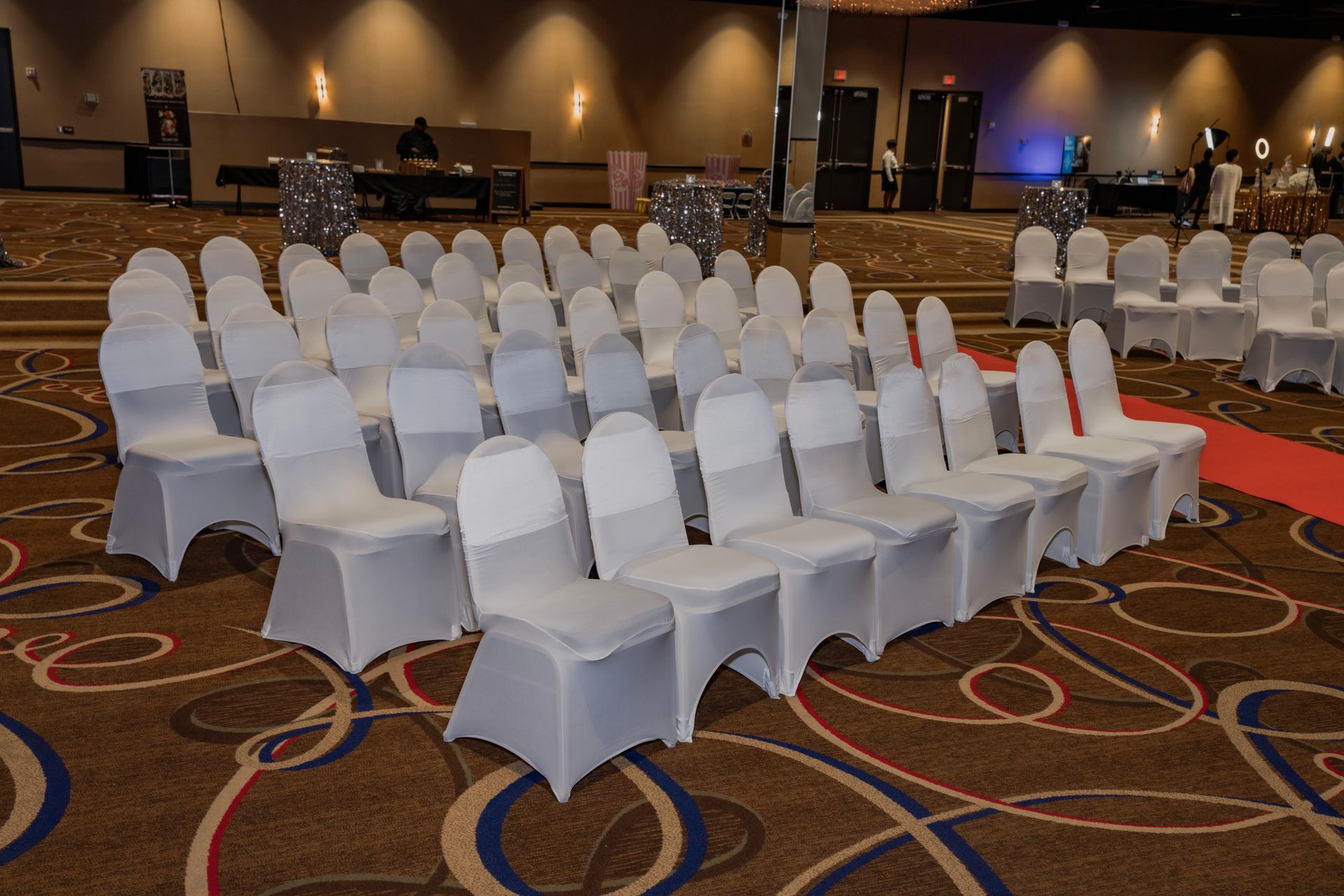 A row of white chairs are lined up in a large room.