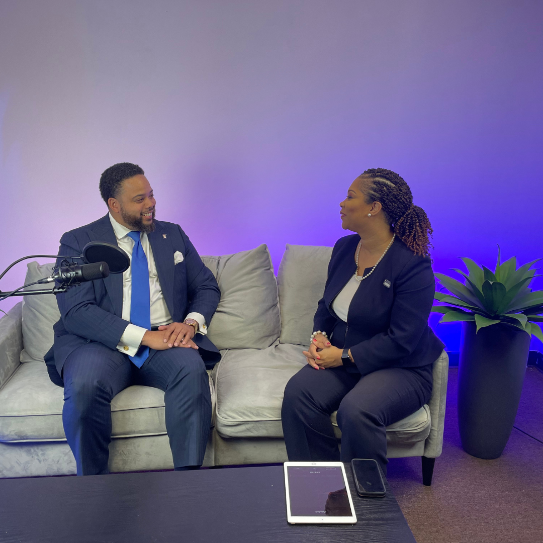 A man and a woman are sitting on a couch talking to each other