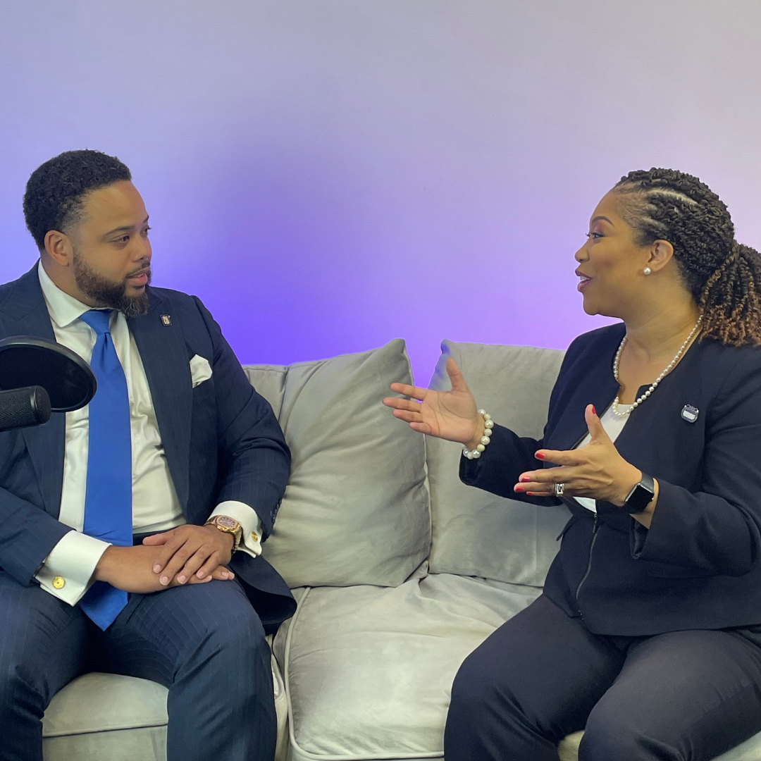 A man and a woman are sitting on a couch talking to each other