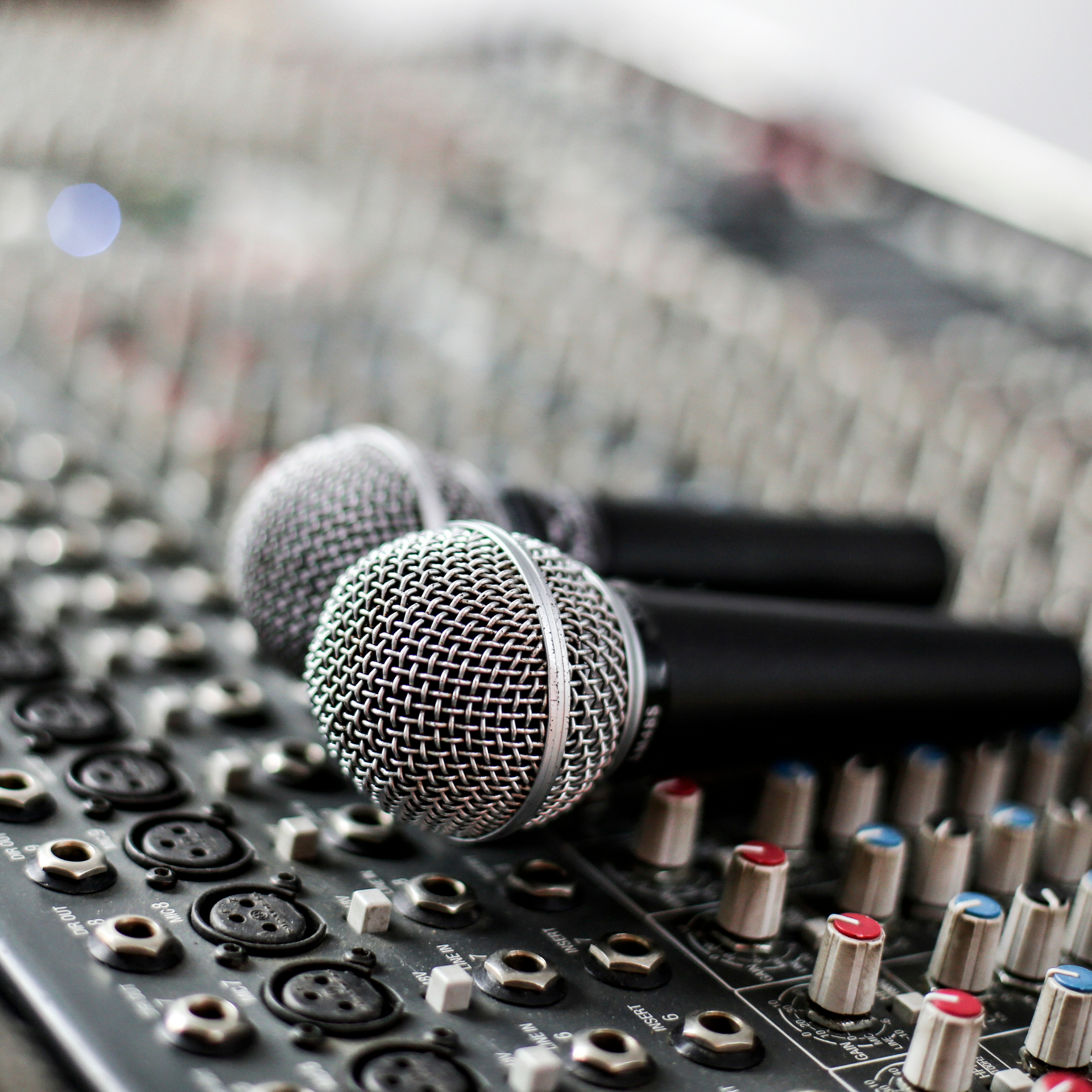 Two microphones are sitting on top of a mixer