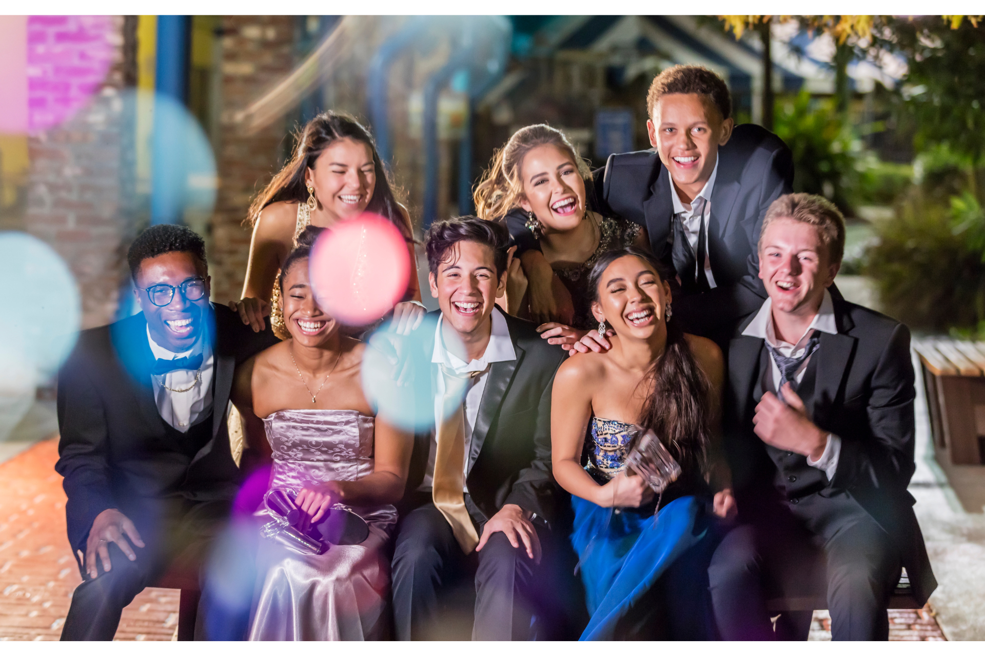 A group of young people are posing for a picture together at a formal event.