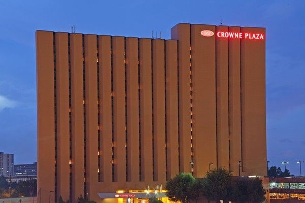 Crowne Plaza hotel building at dusk with illuminated sign.