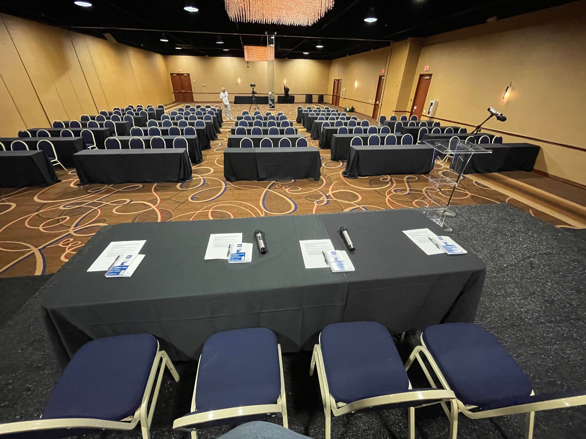 A large conference room with rows of tables and chairs