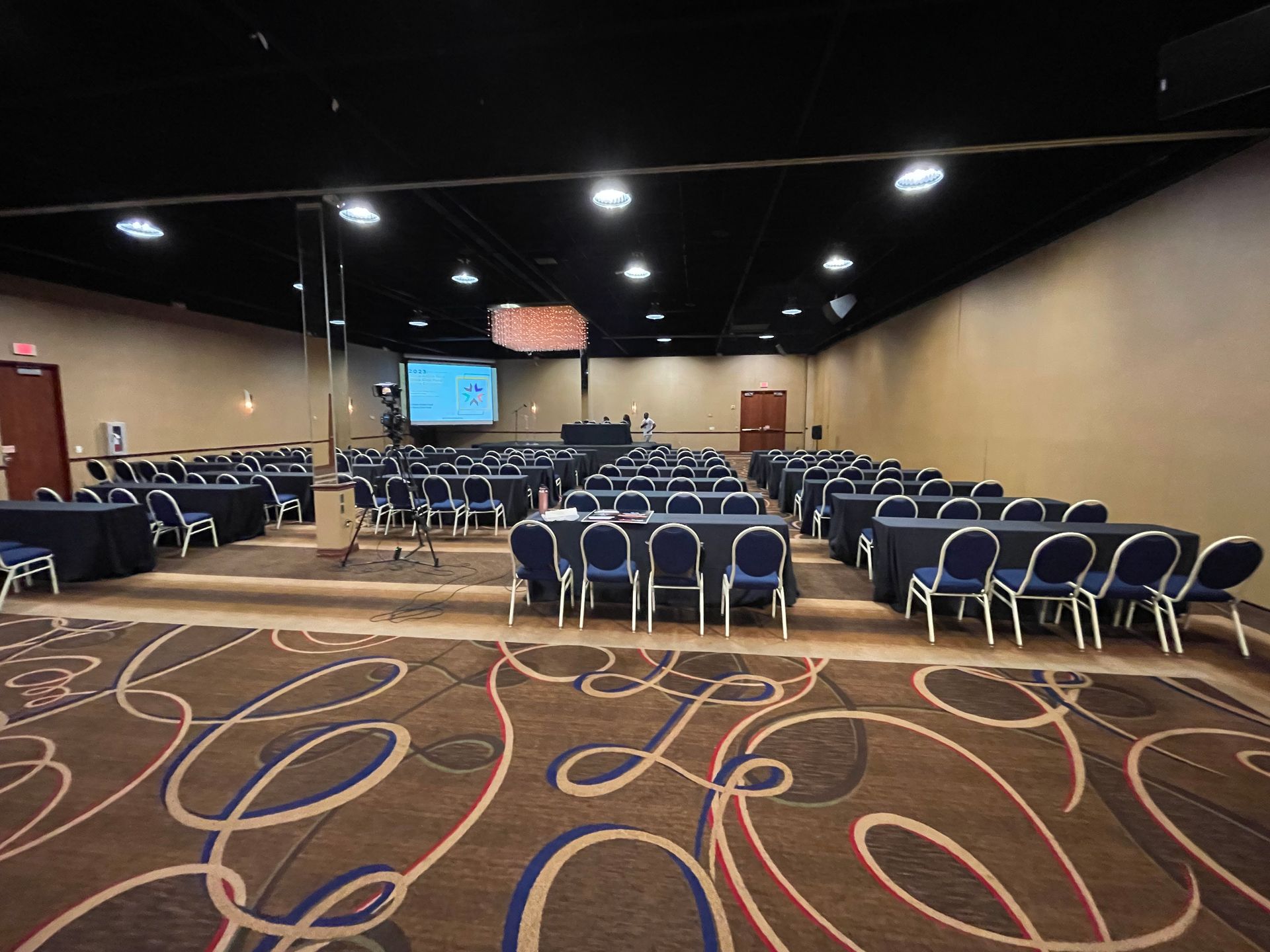 A large conference room with tables and chairs set up for a meeting