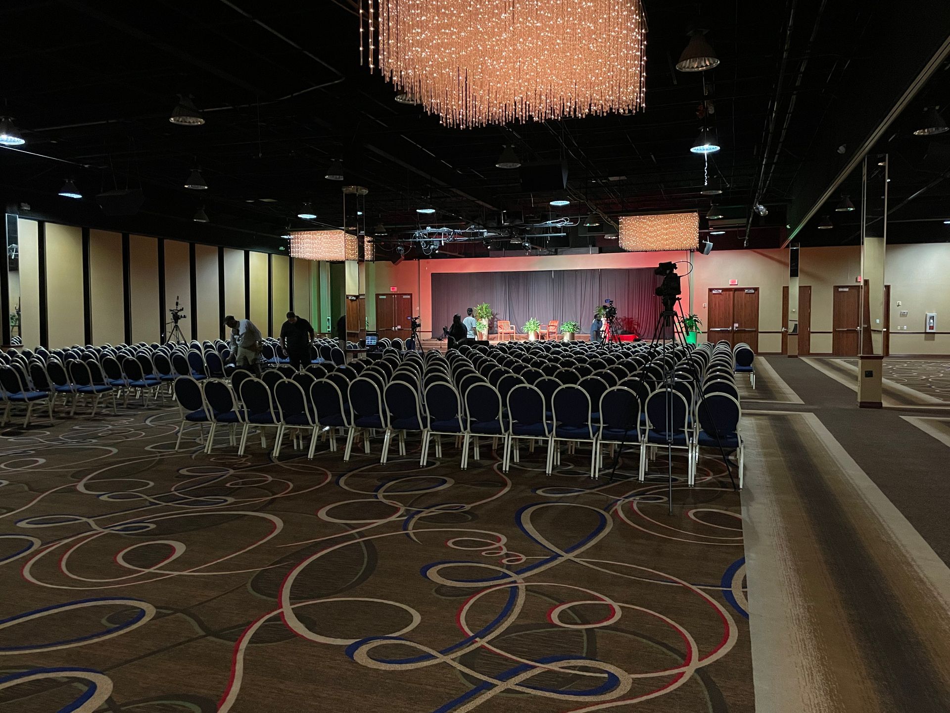 A large auditorium with rows of chairs and a stage.
