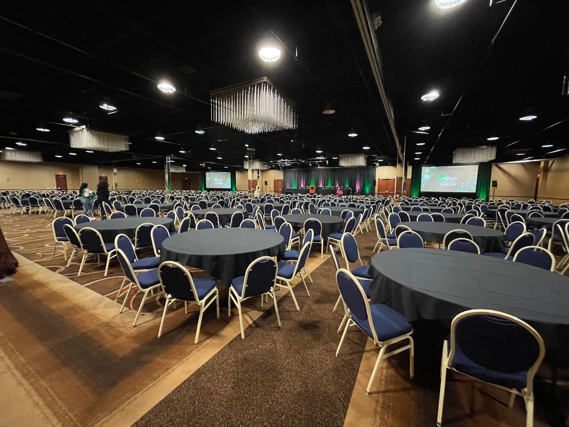 A large room with tables and chairs set up for a conference.