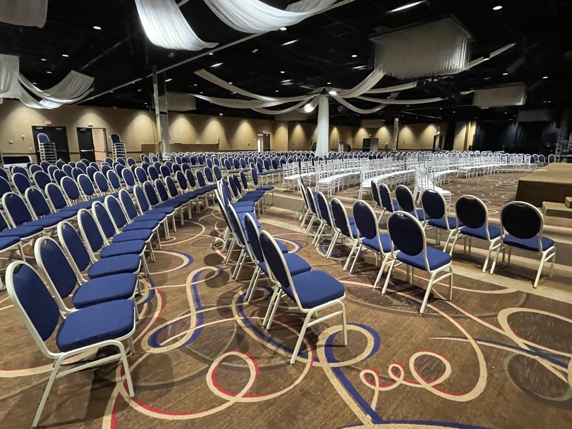 Rows of blue chairs are lined up in a large room