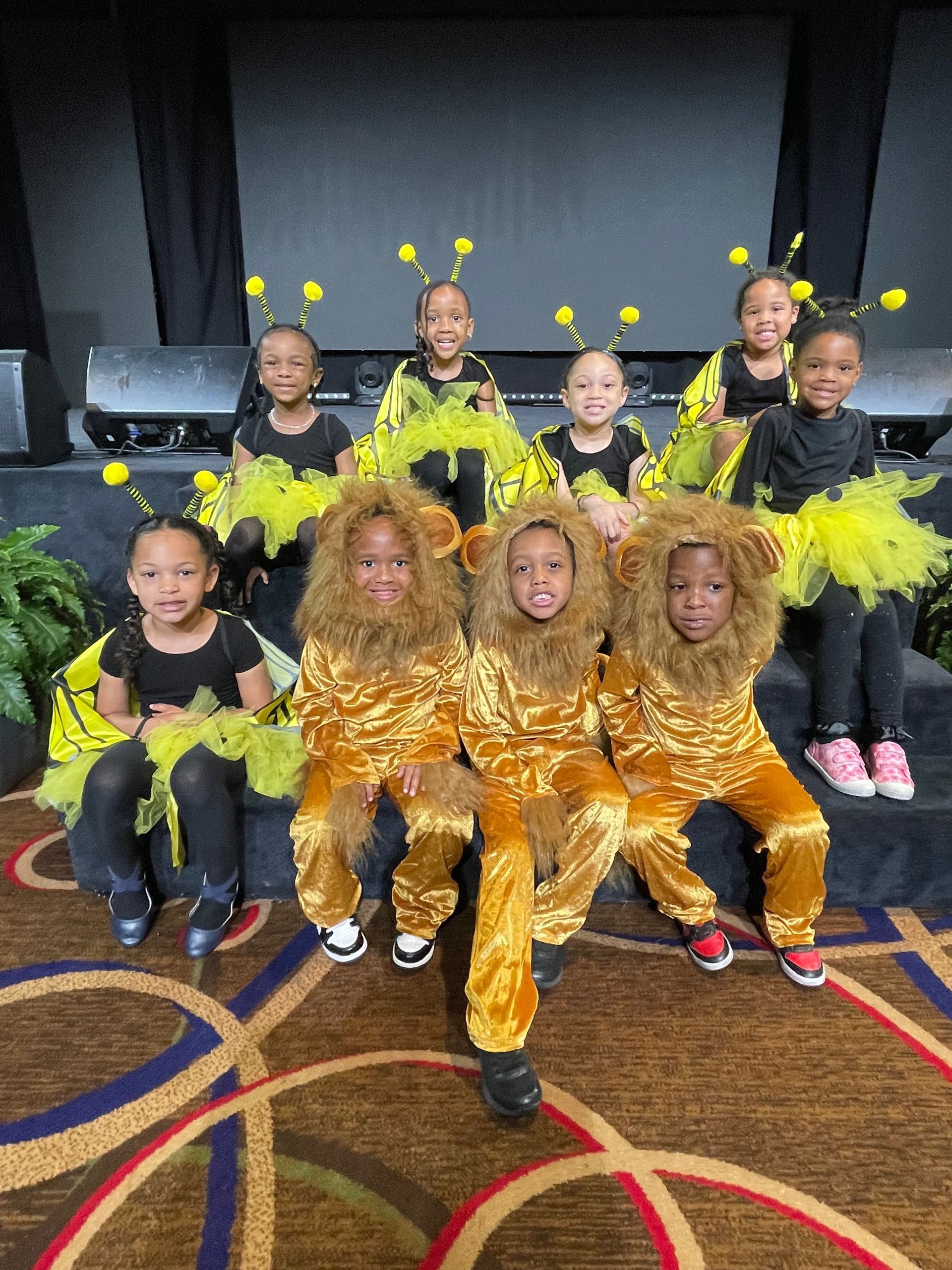 A group of children dressed in lion costumes are posing for a picture.