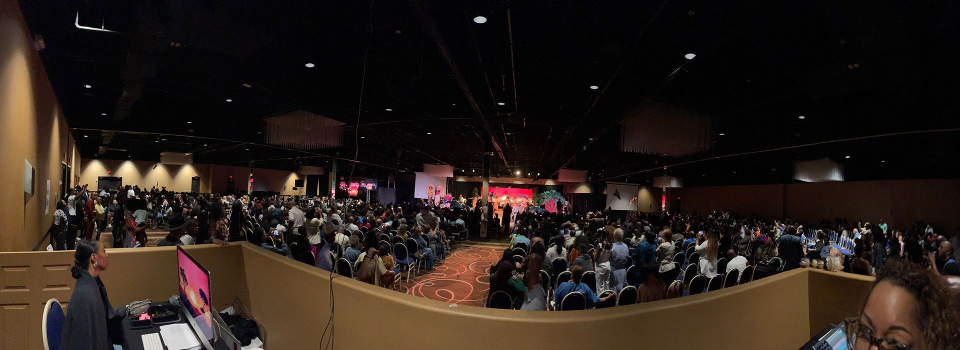 A large crowd of people are sitting in a large auditorium.