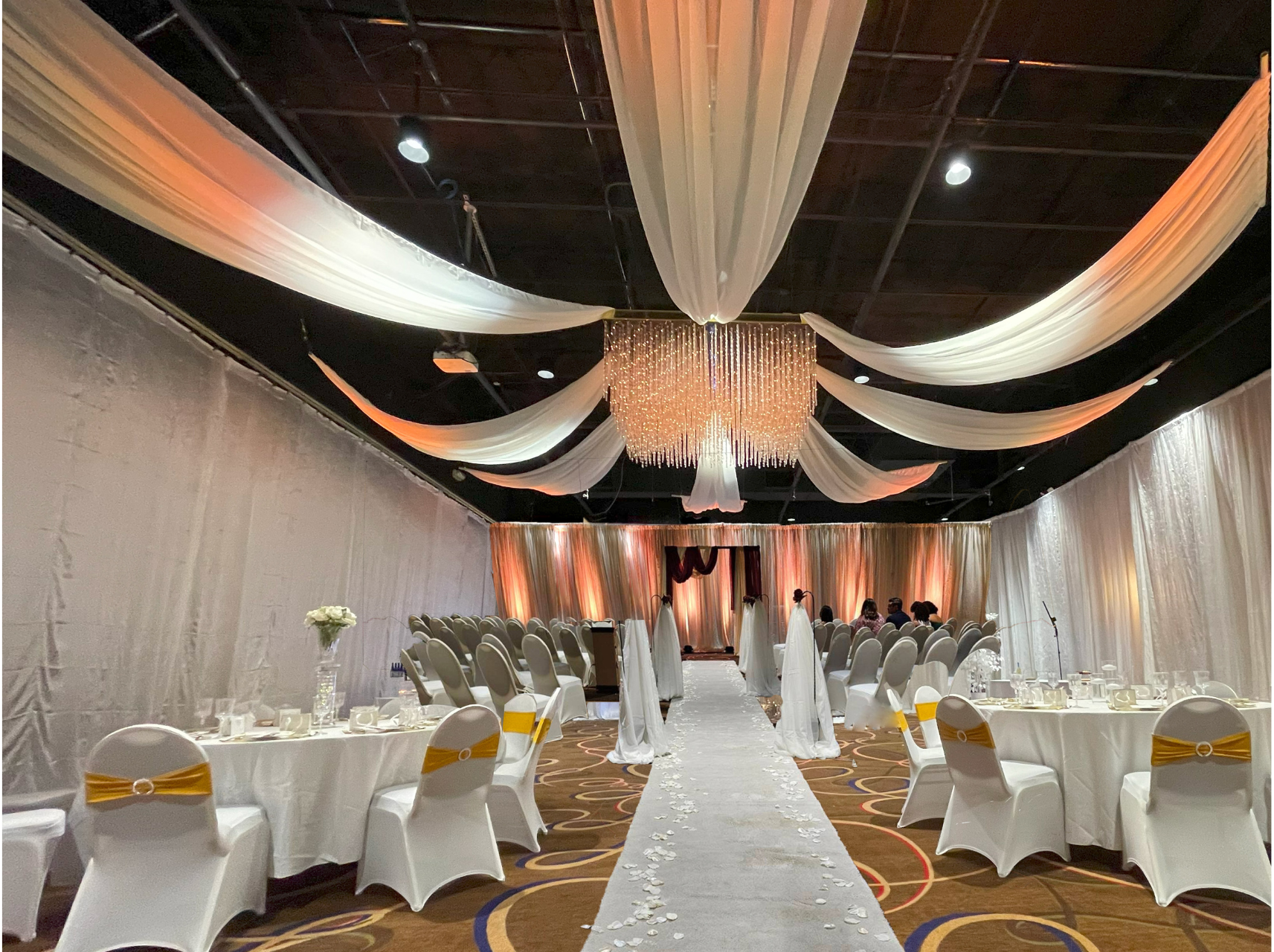 A large room with tables and chairs set up for a wedding reception.