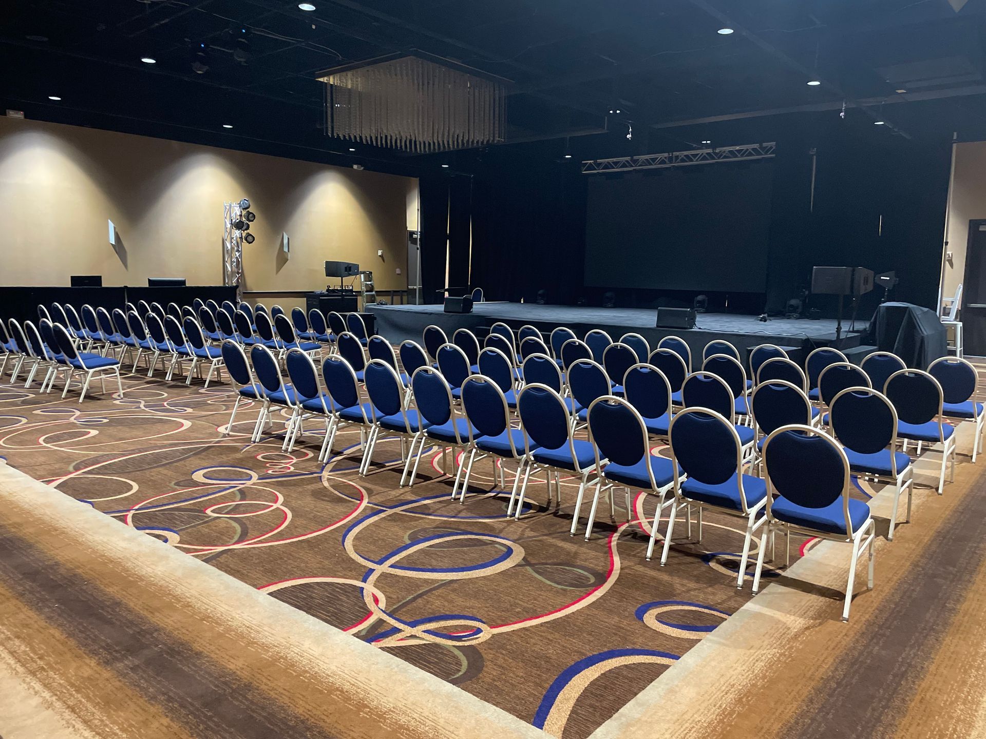 A large auditorium with rows of chairs and a stage.