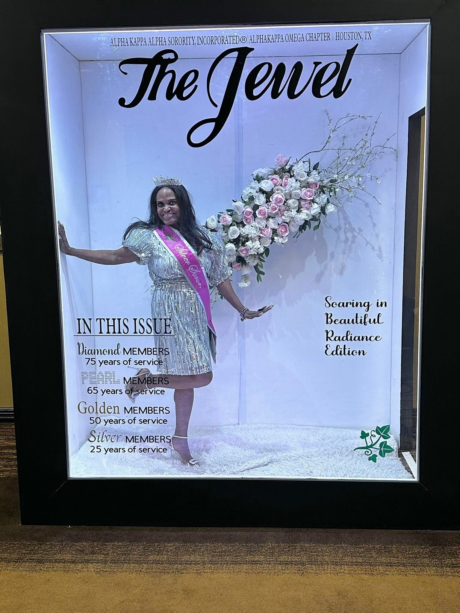 A woman posing in front of a floral display in a custom photo box