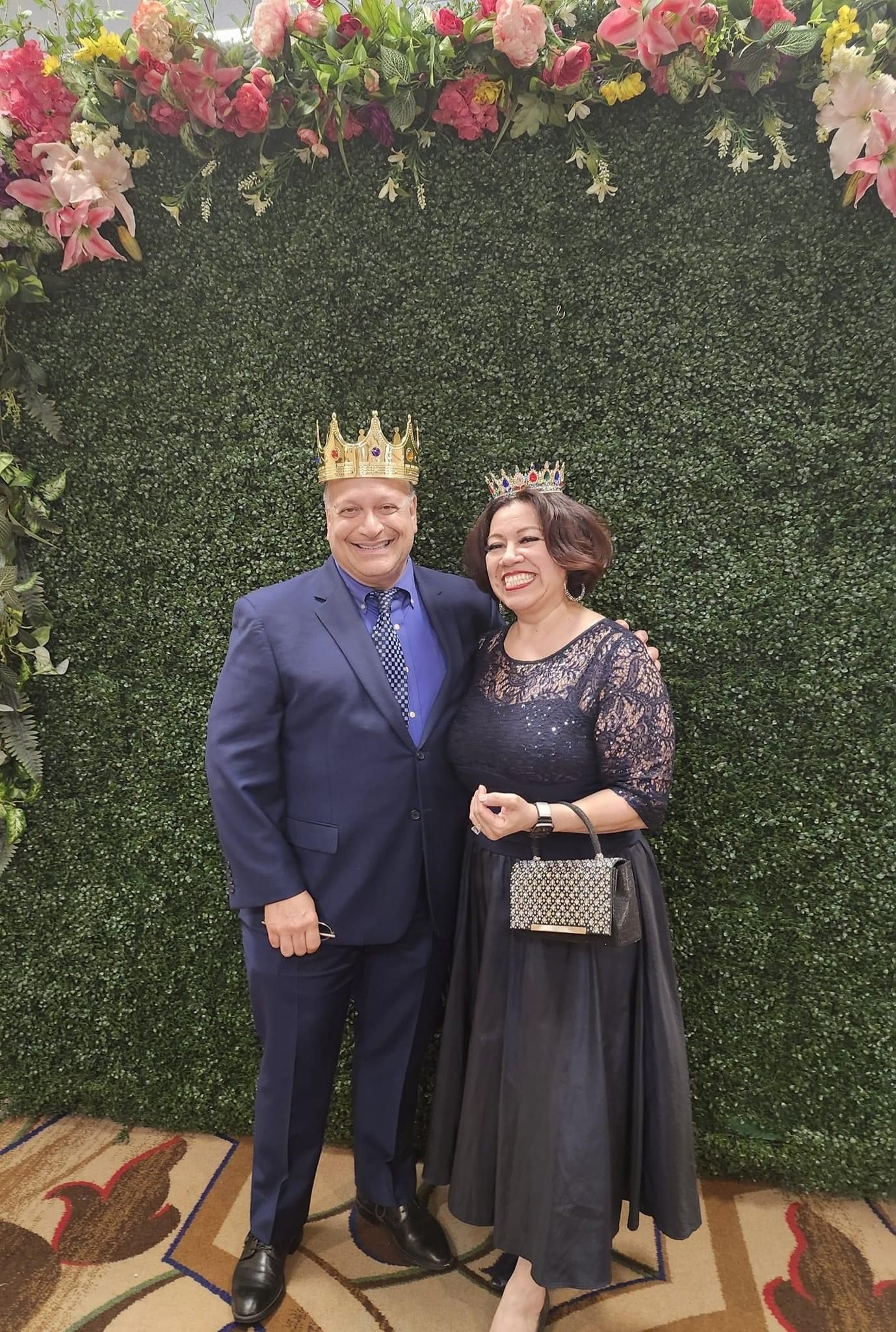 A man and a woman wearing crowns are posing for a picture.