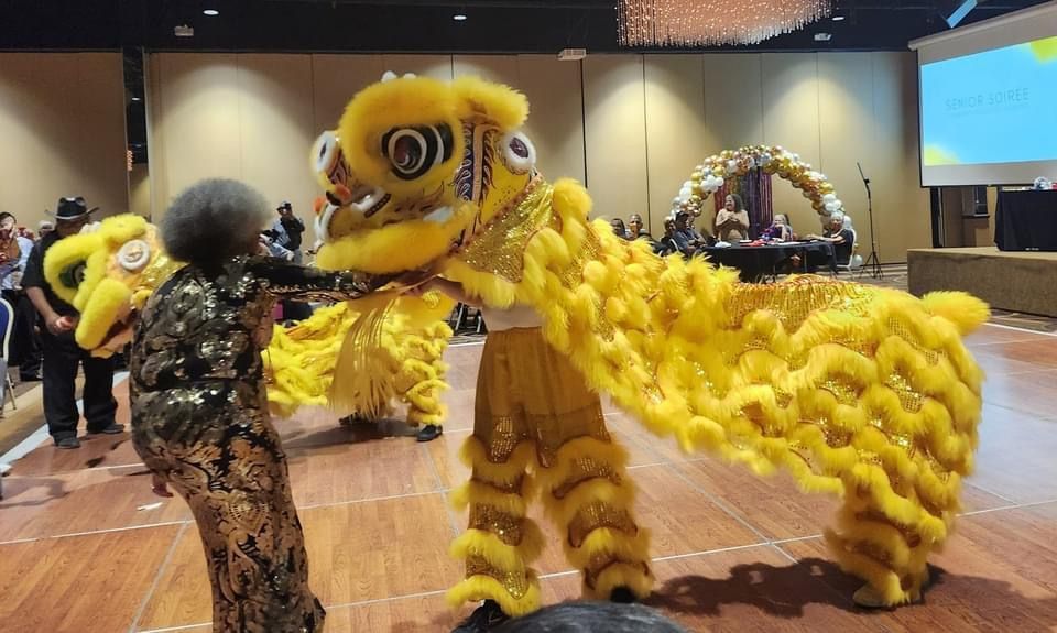A woman is standing next to a lion costume on a dance floor.