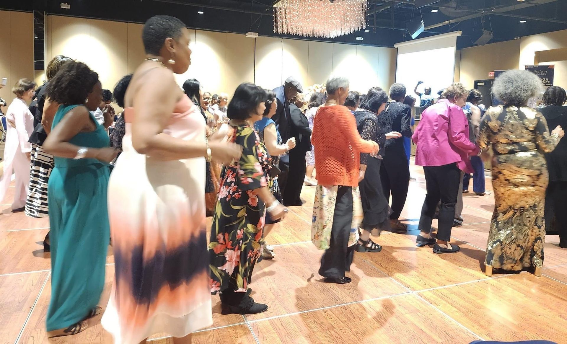 A group of women are dancing in a large room