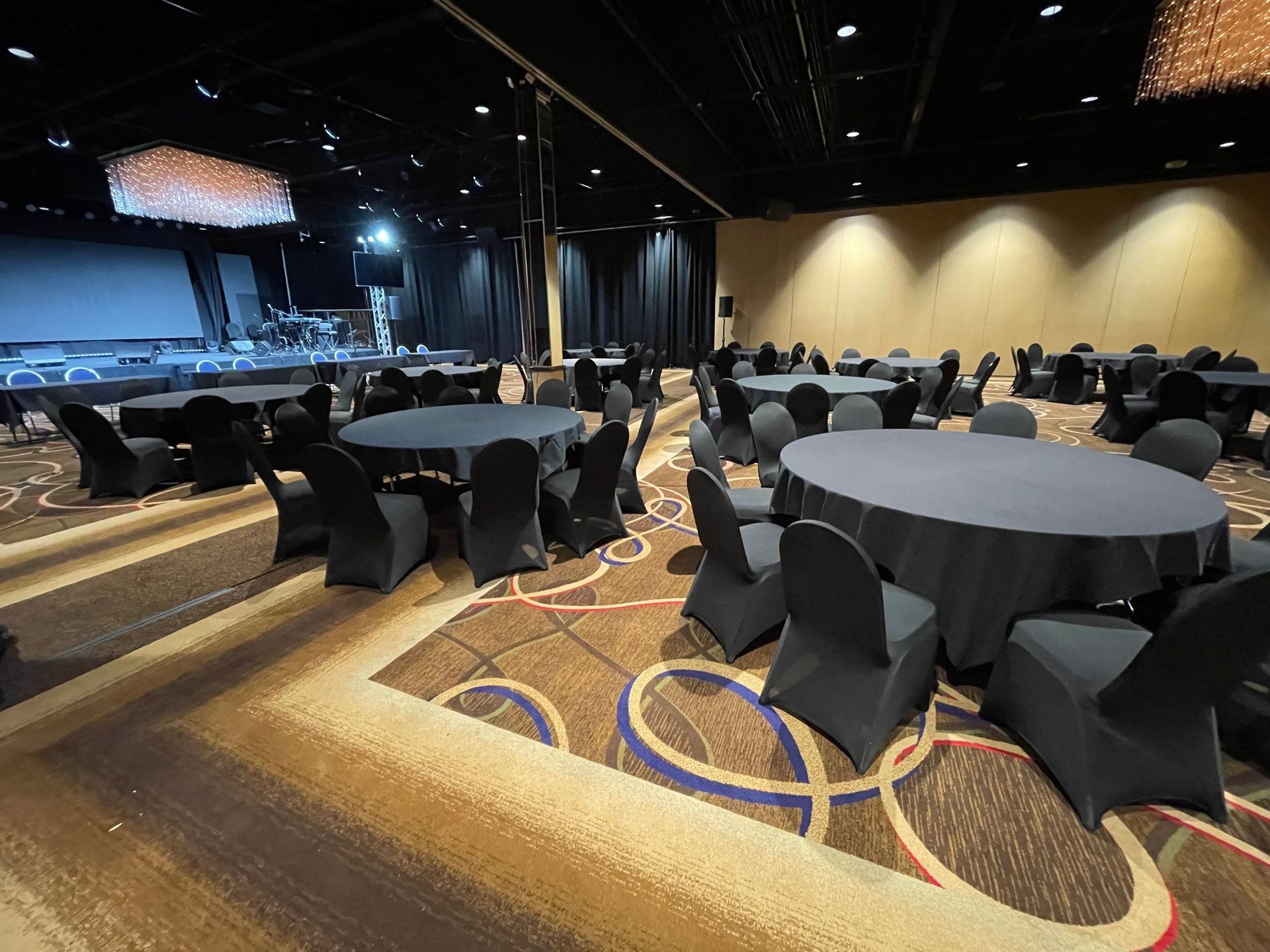A large room with tables and chairs set up for a party.
