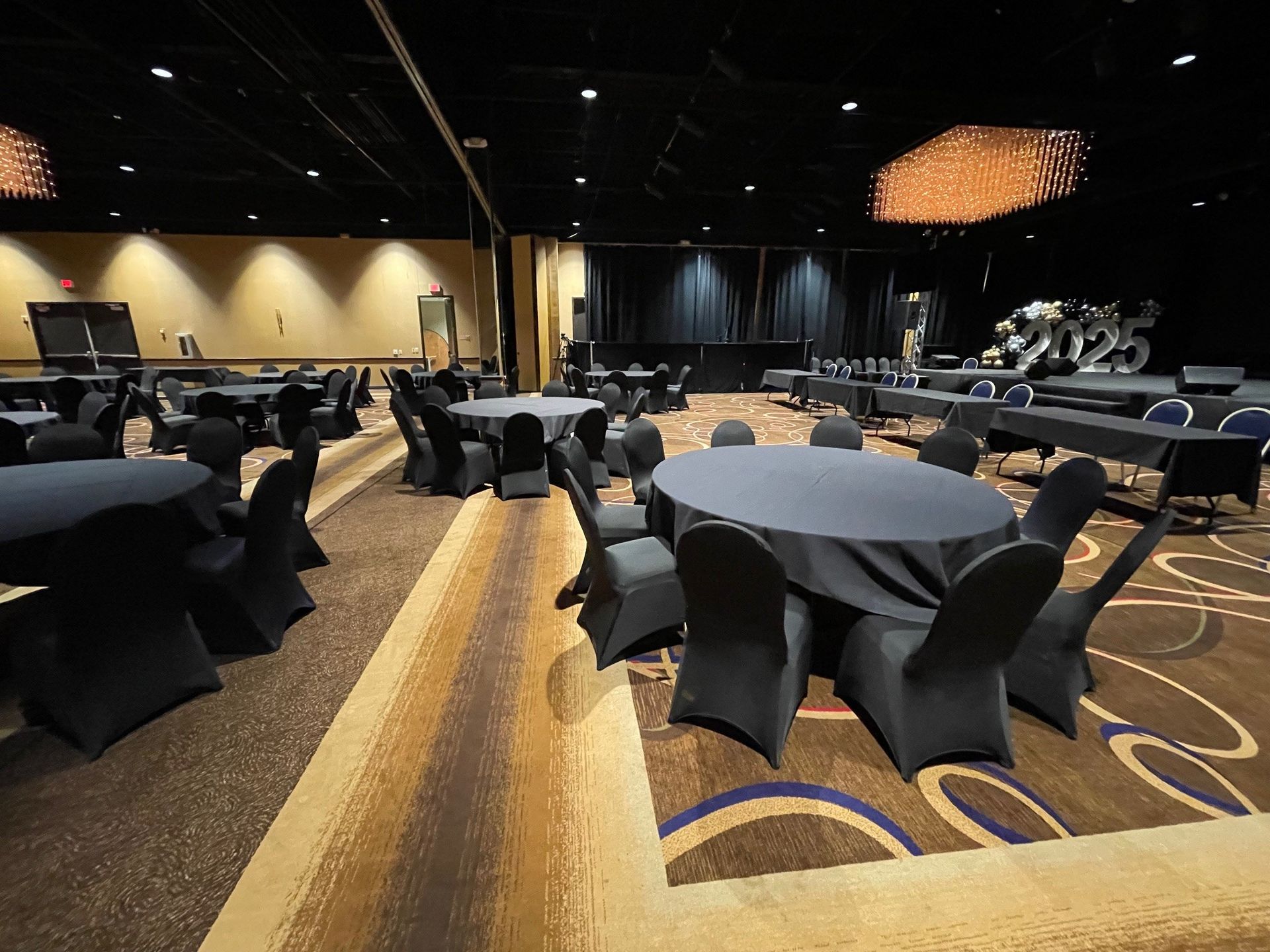 A large room with tables and chairs set up for a party