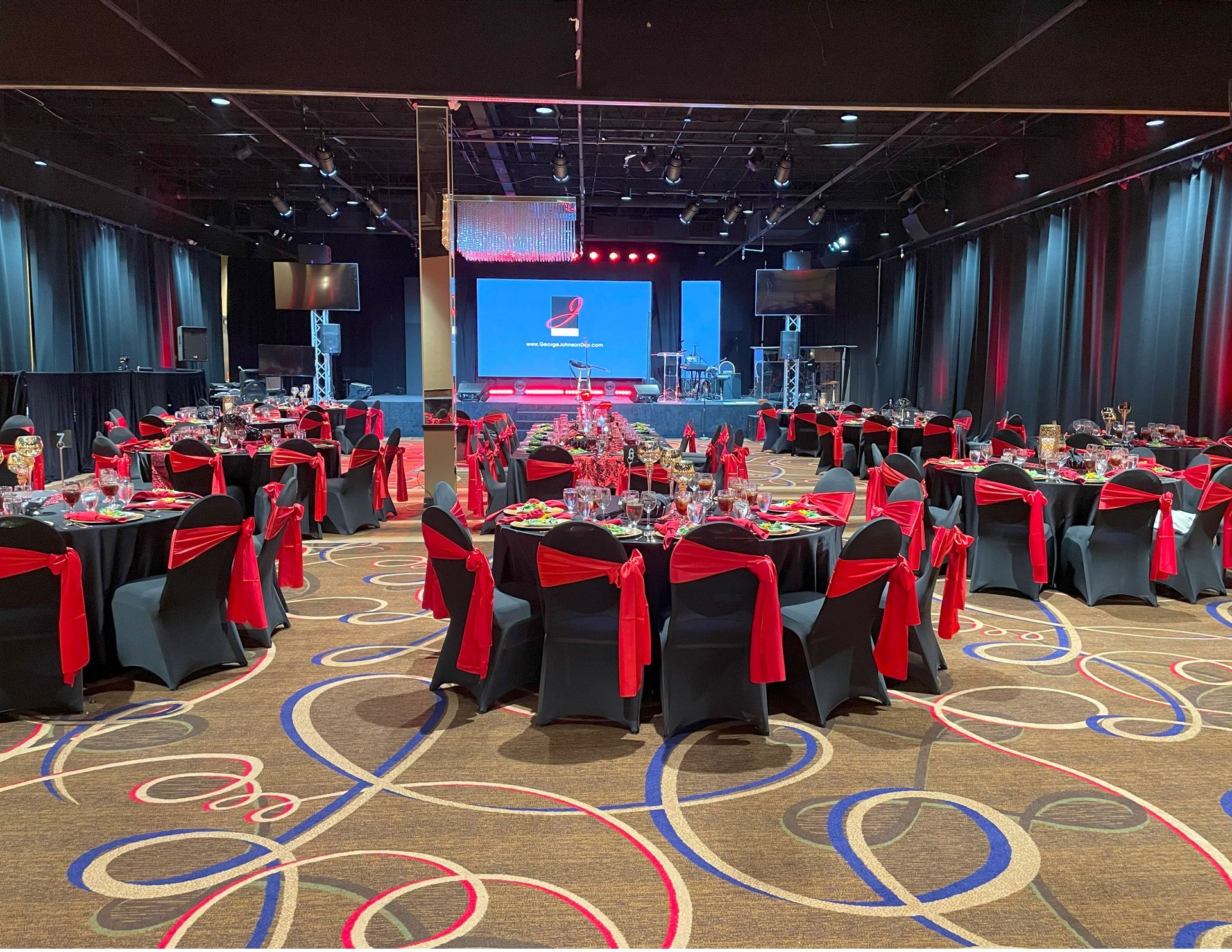 A large room with tables and chairs set up for a party.