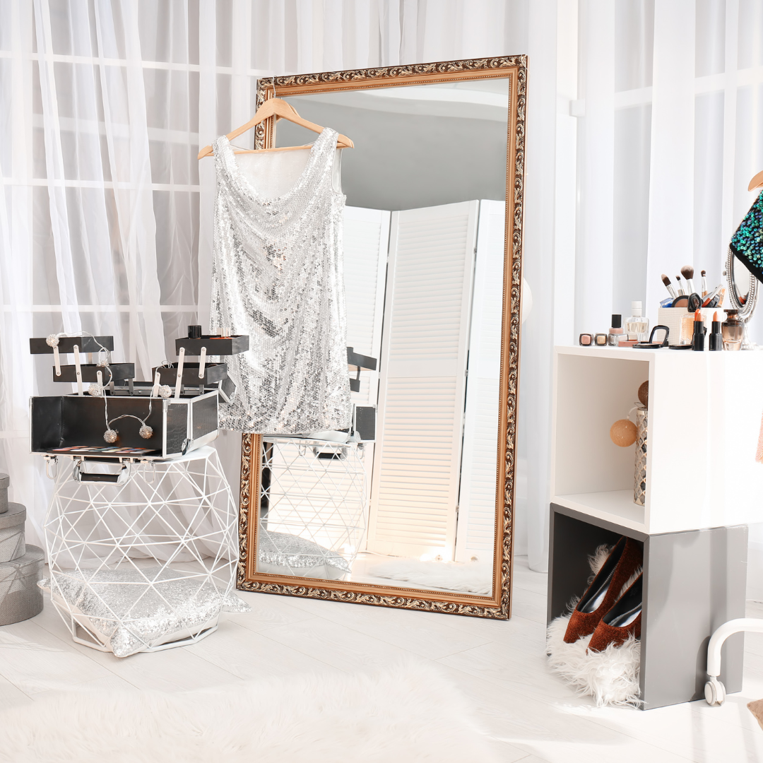 A full-length mirror in a room with a dress on a hanger.
