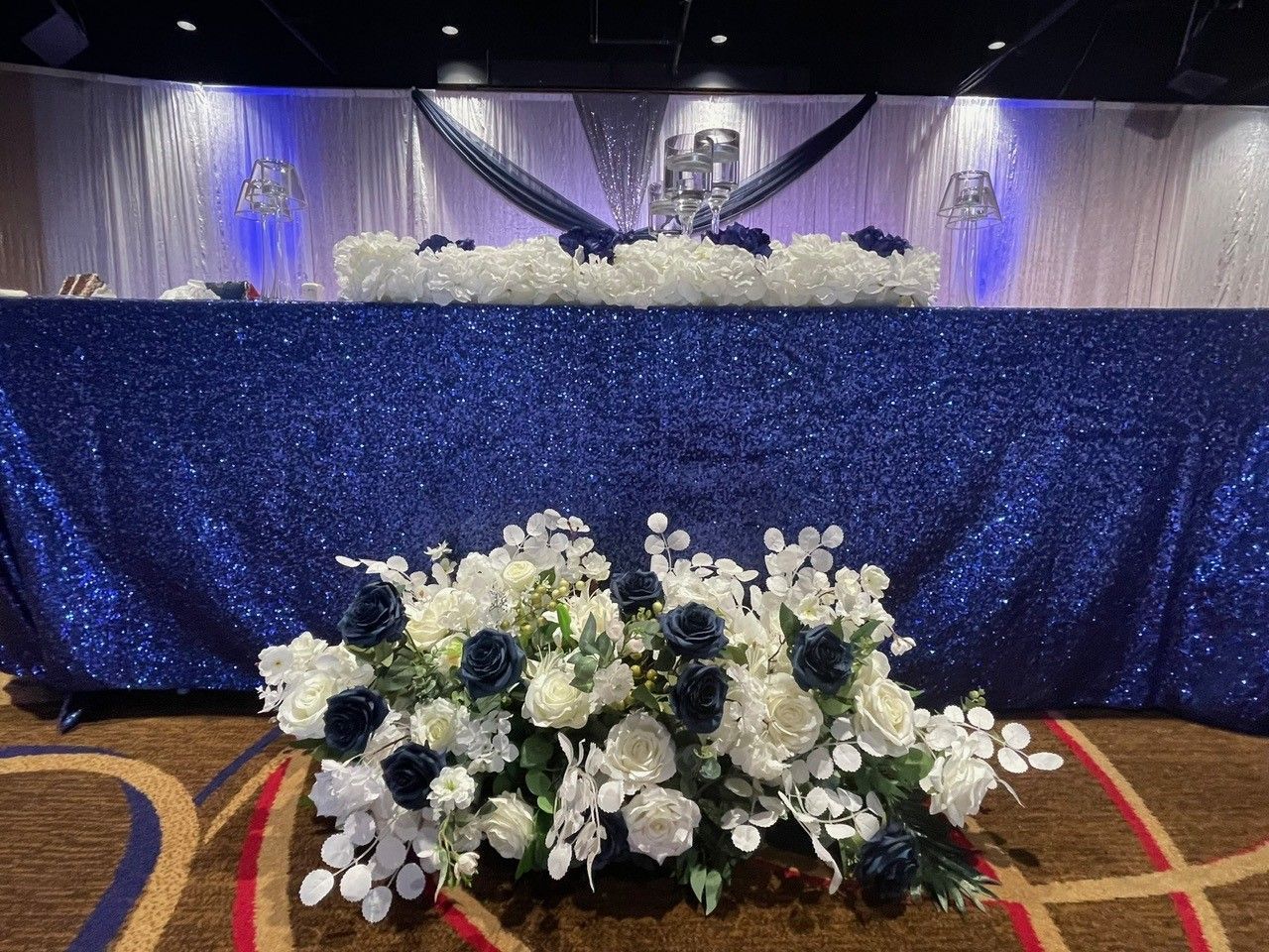 A table with a blue tablecloth and white flowers on it.