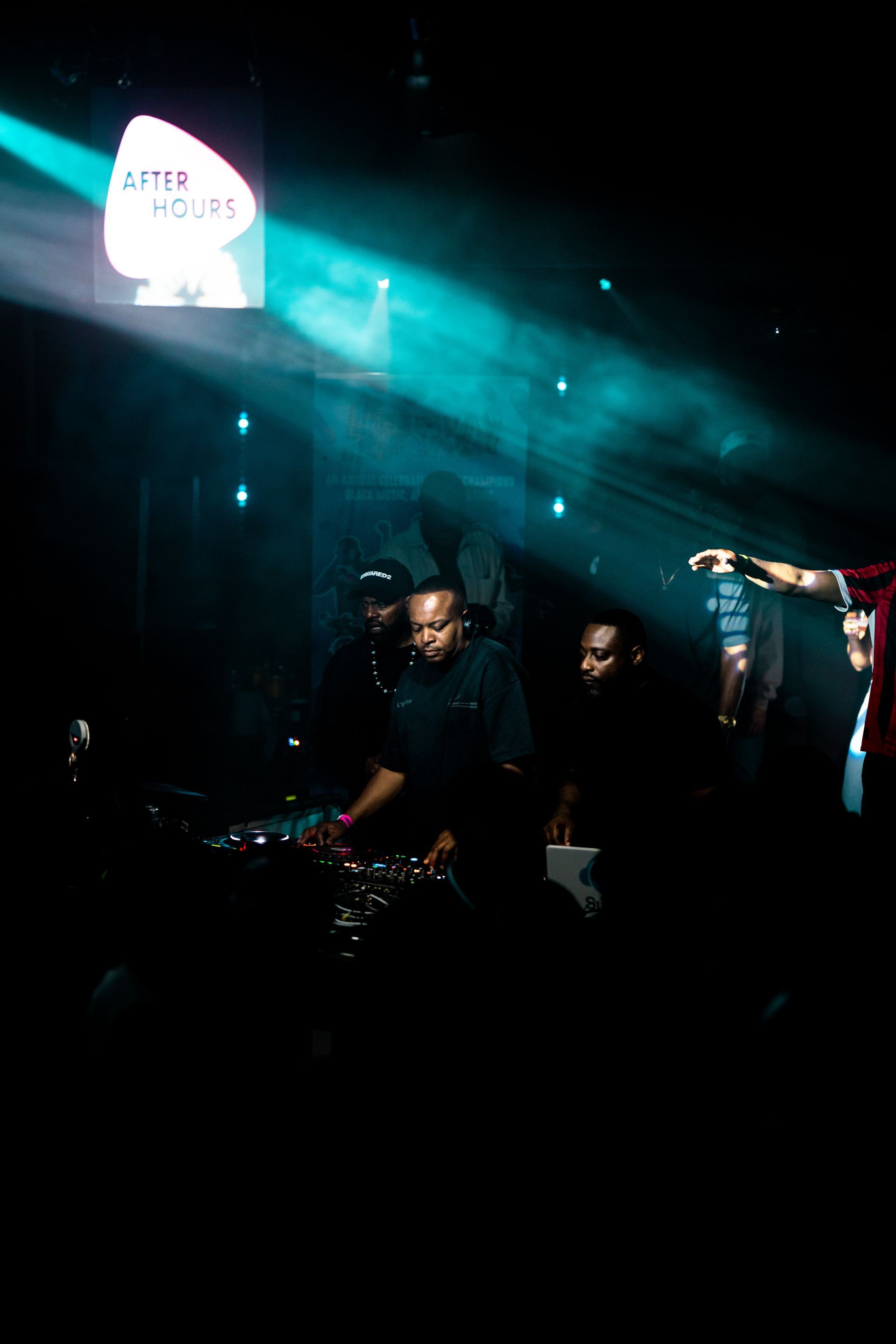 A group of people are dancing in a dark room with a sign that says app house