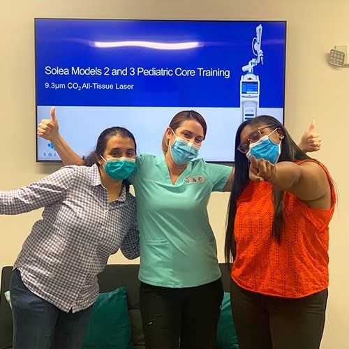 Dental Studio 4 Kids staff wearing masks and showing thumbs up