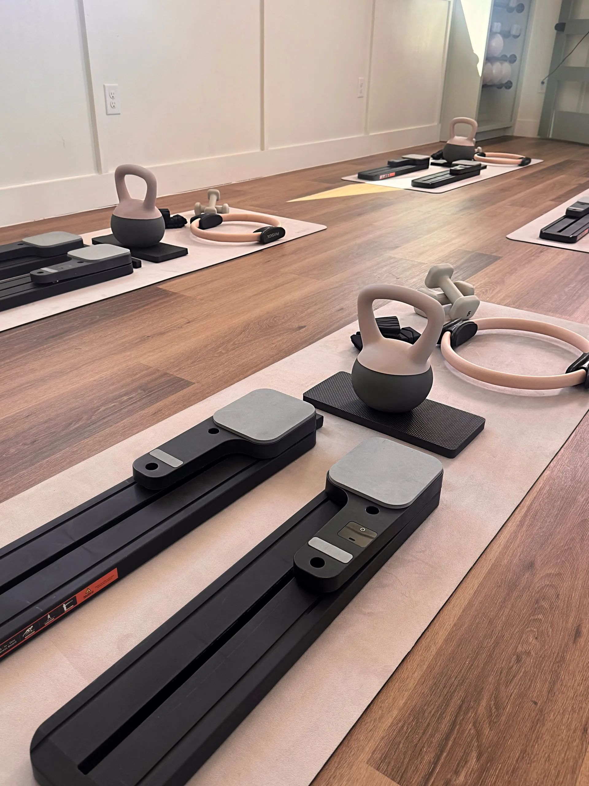 Fitness room with kettlebells, resistance bands, and exercise equipment on a mirrored floor