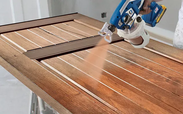 A Person is Spraying Paint on a Wooden Table — Dynamic 2-Pack In Rockville, QLD