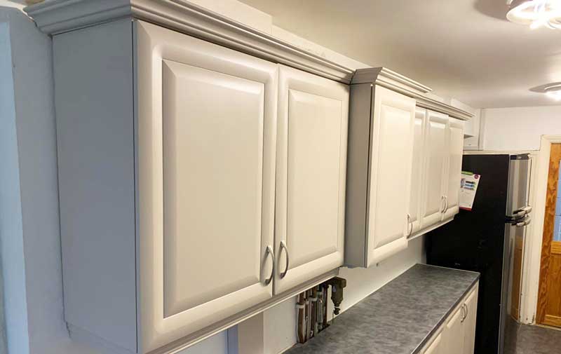 A Kitchen With White Cabinets and a Black Refrigerator — Dynamic 2-Pack In Rockville, QLD