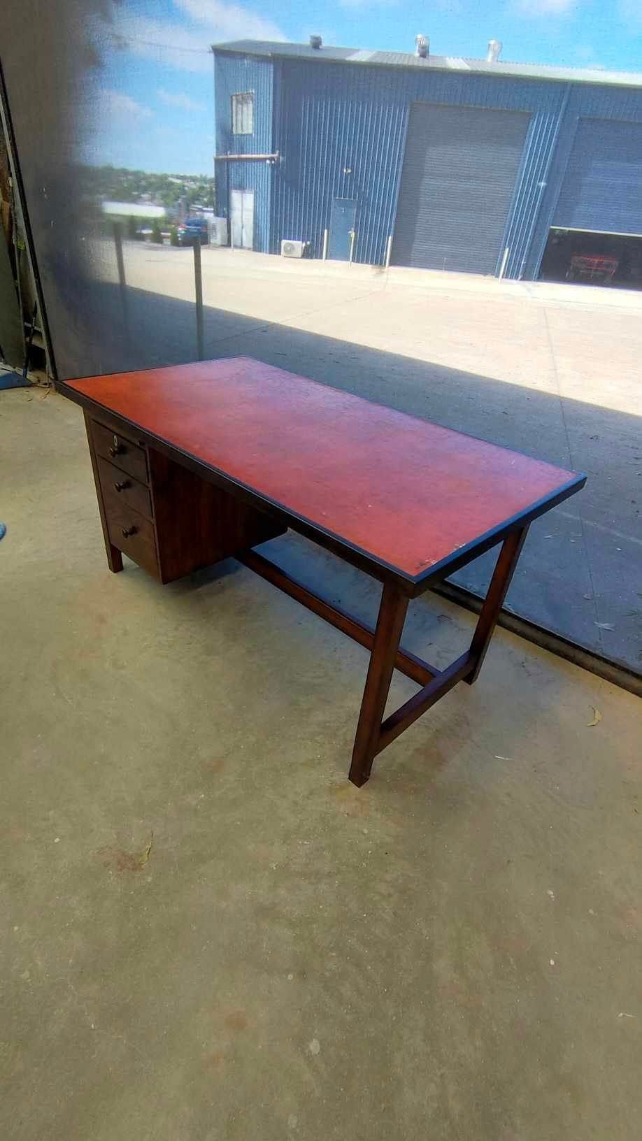 A Red Wooden Desk With Drawers is Sitting on a Concrete Floor in Front of a Building — Dynamic 2-Pack In Rockville, QLD