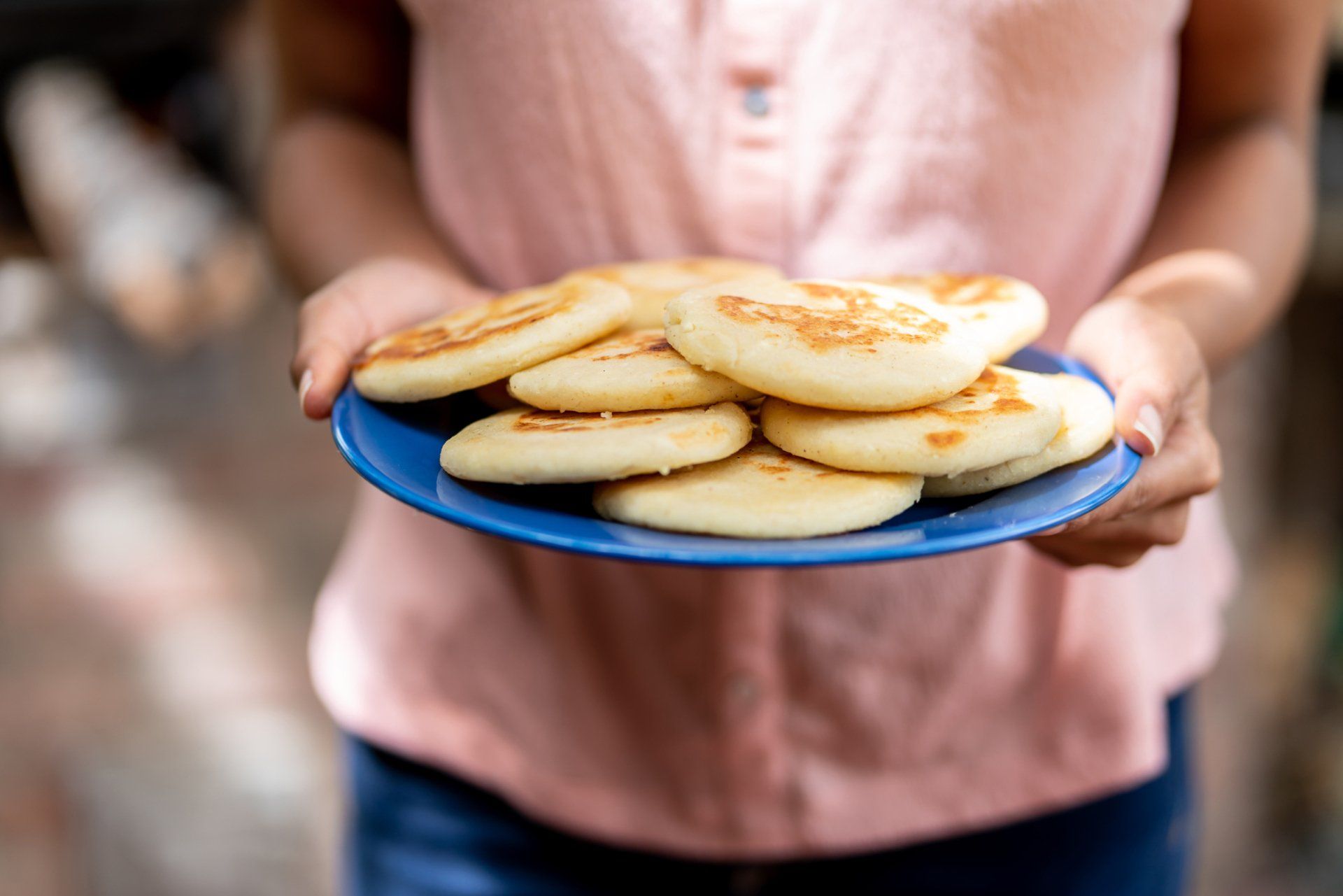 Woman holding plate of arepas — Harrisburg, PA — Arepa House