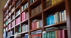 Una biblioteca piena di libri su scaffali di legno.
