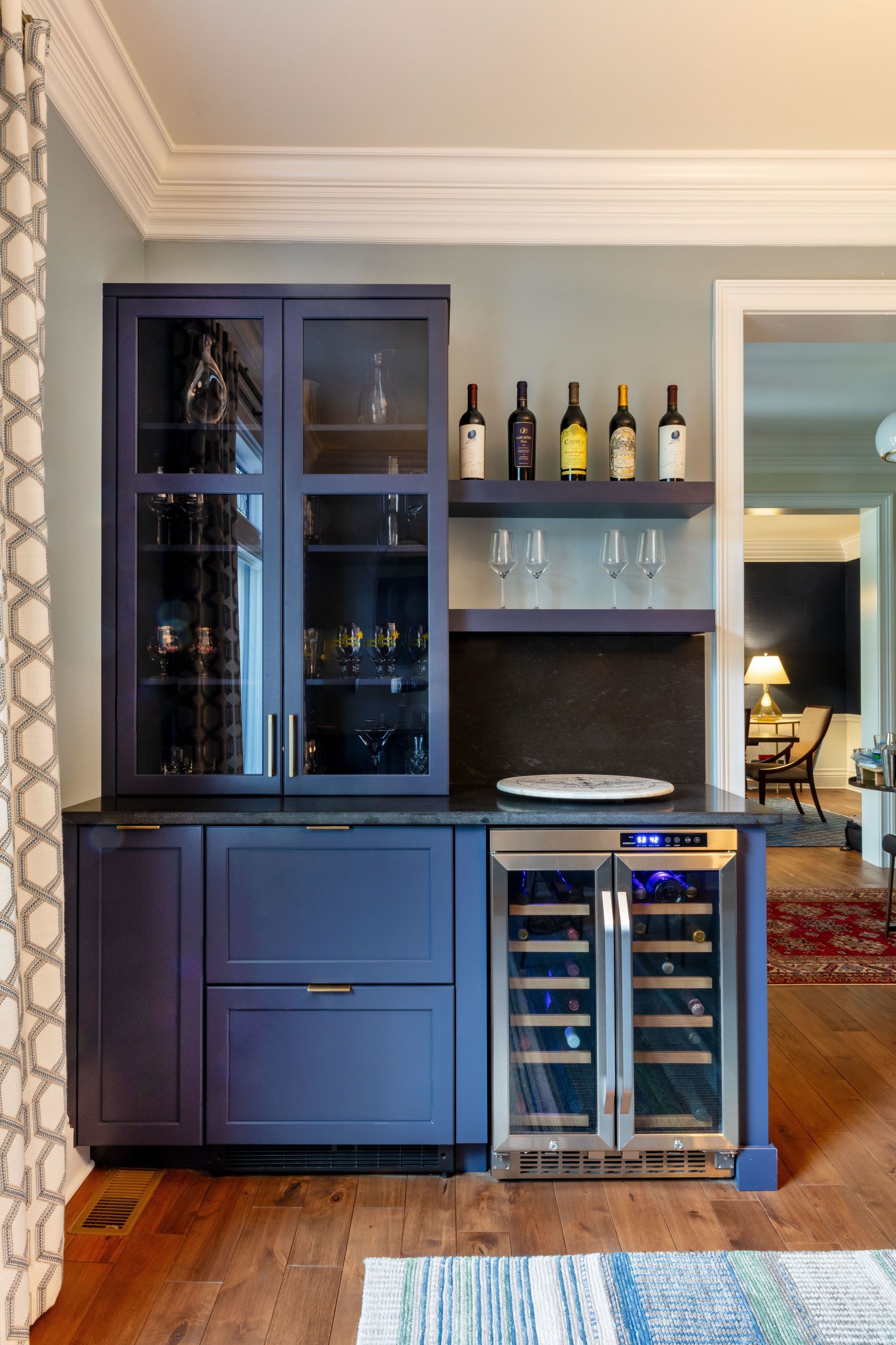 Blue built-in bar cabinet with wine storage in a living room doorway