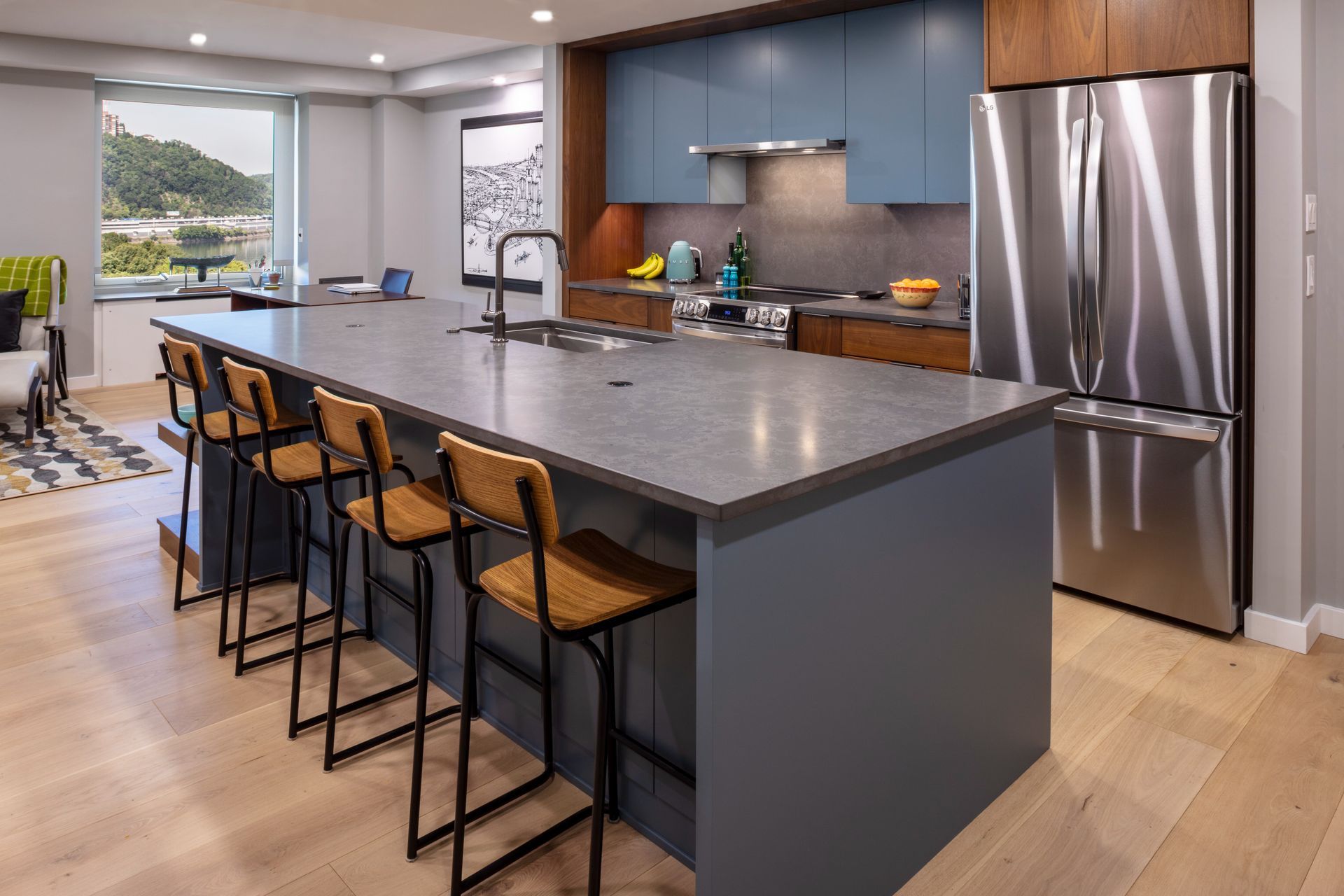 Modern kitchen with a large island, bar stools, stainless steel appliances, and blue-gray cabinets
