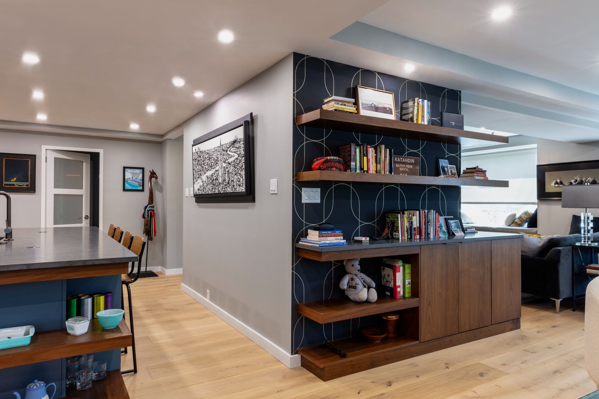 Modern open-concept home interior with built-in shelves, kitchen island, and dining area